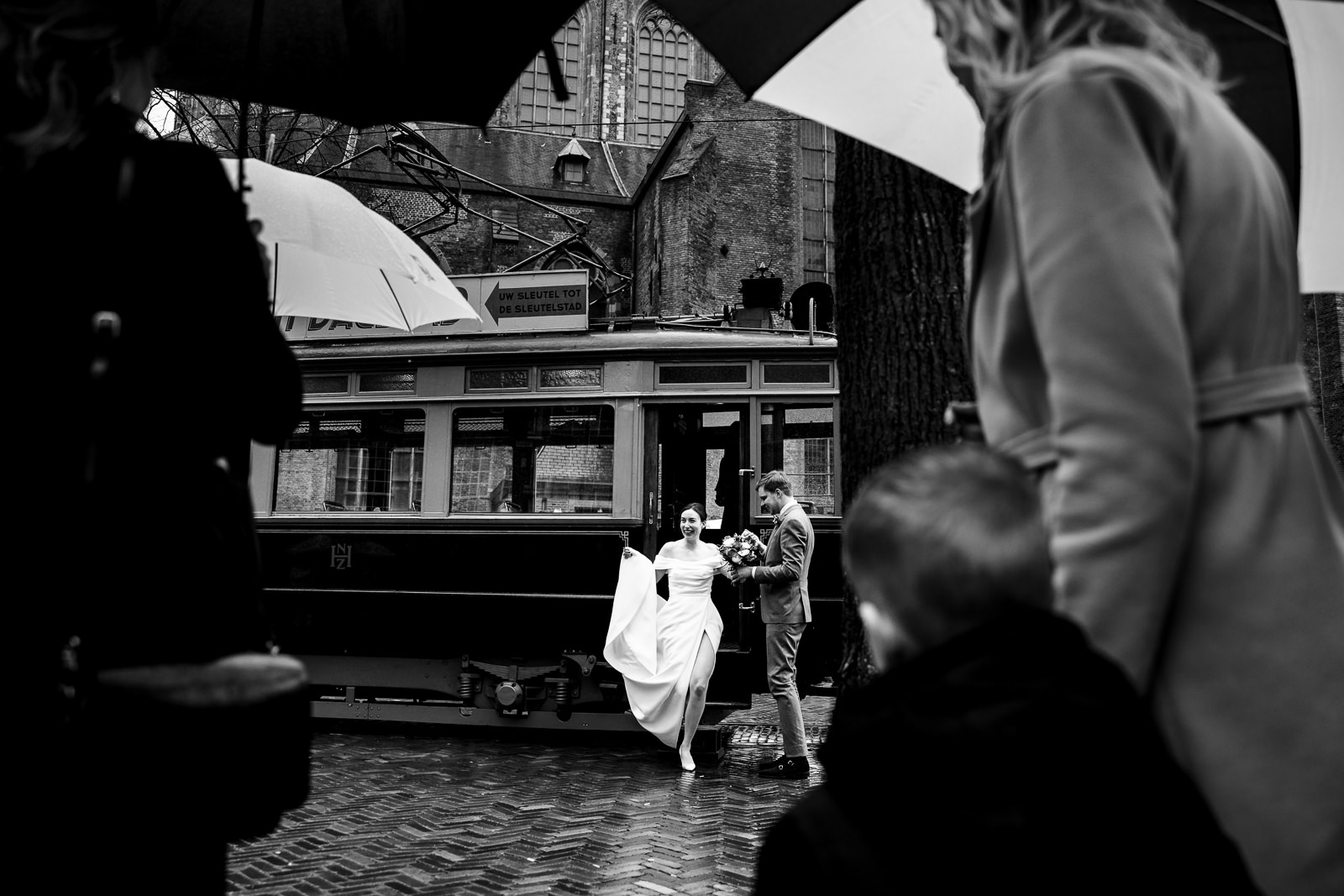 Bruidspaar stapt uit trouwvervoer en worden opgewacht door alle gasten vastgelegd door Trouwfotograaf Den Haag Paco van Leeuwen