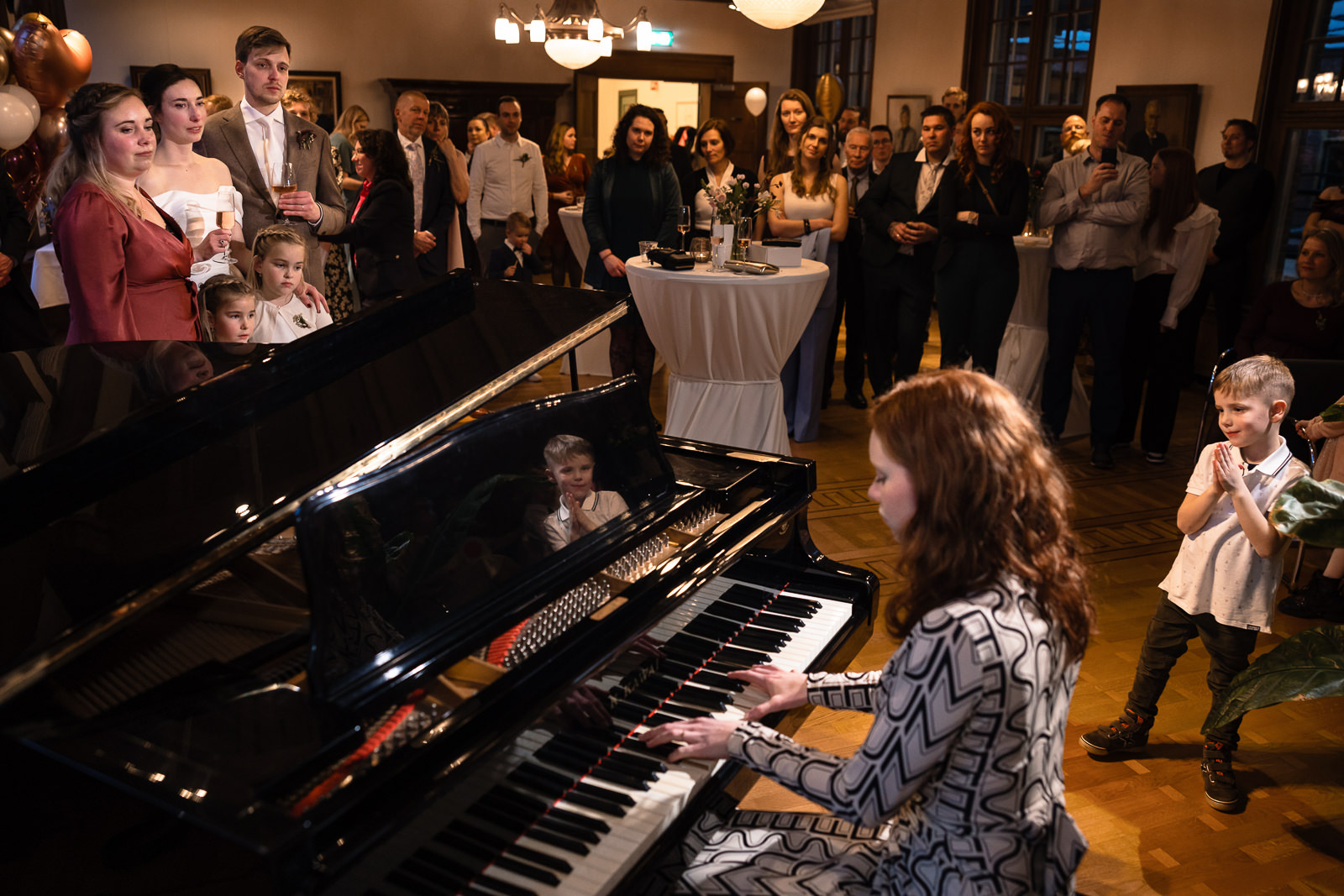 Nichtje van het bruidspaar speelt een mooi emotioneel klassiek stuk op de piano vastgelegd door Trouwfotograaf Den Haag Paco van Leeuwen