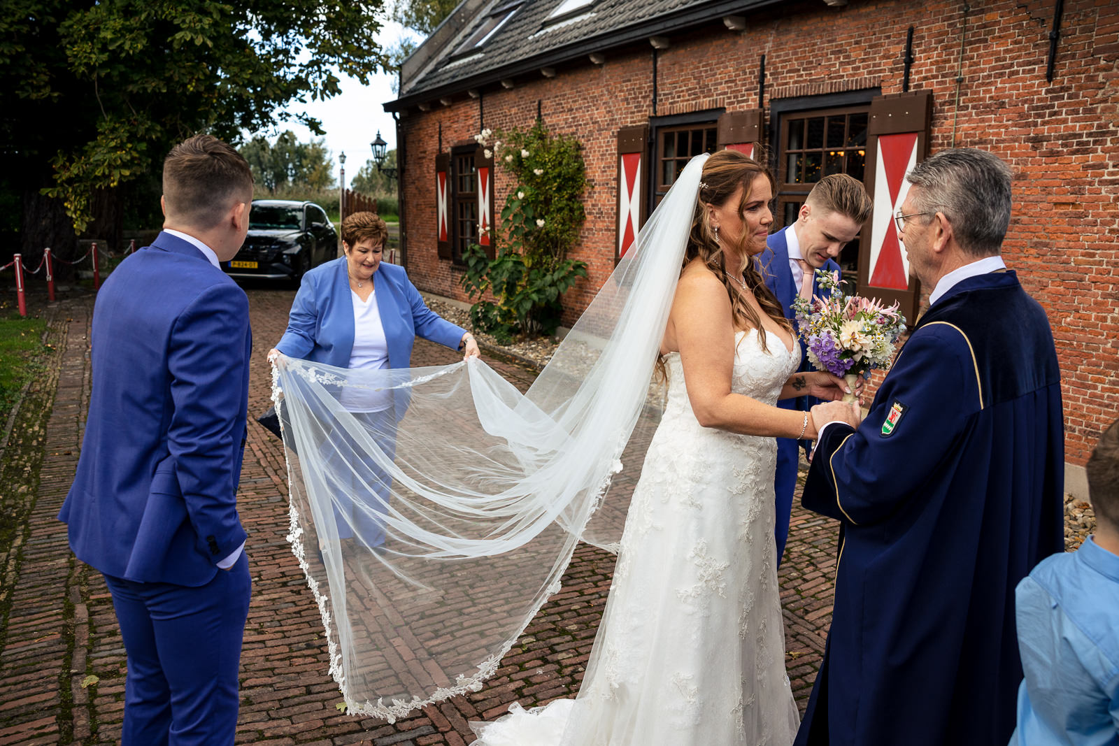 Trouwfotograaf Westland aankomst bruid en moeder helpt met de sluier