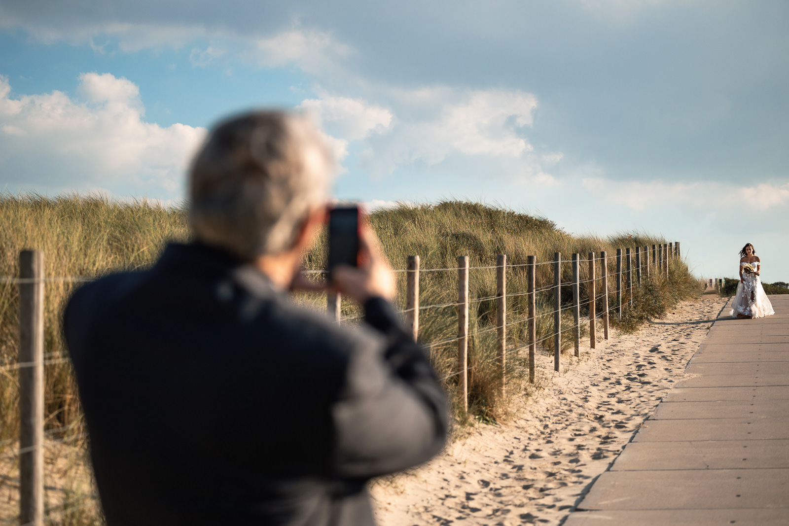 Father of the bride takes picture of his daughter when she walks dow to him to seem him for the first time on her wedding day Intimate Beach Wedding Photographer