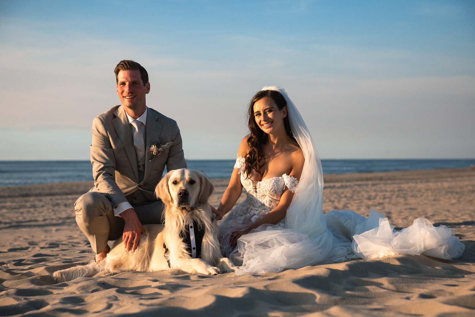 Bride and groom with their dog family portrait Intimate beach wedding