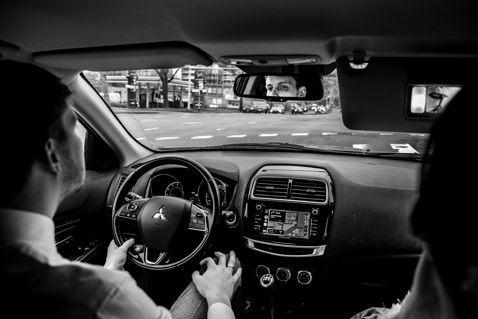 Bruidspaar in de auto, bruidegom rijdt en bruid doet haar make-up bijwerken vastgelegd door Trouwfotograaf Den Haag Paco van Leeuwen