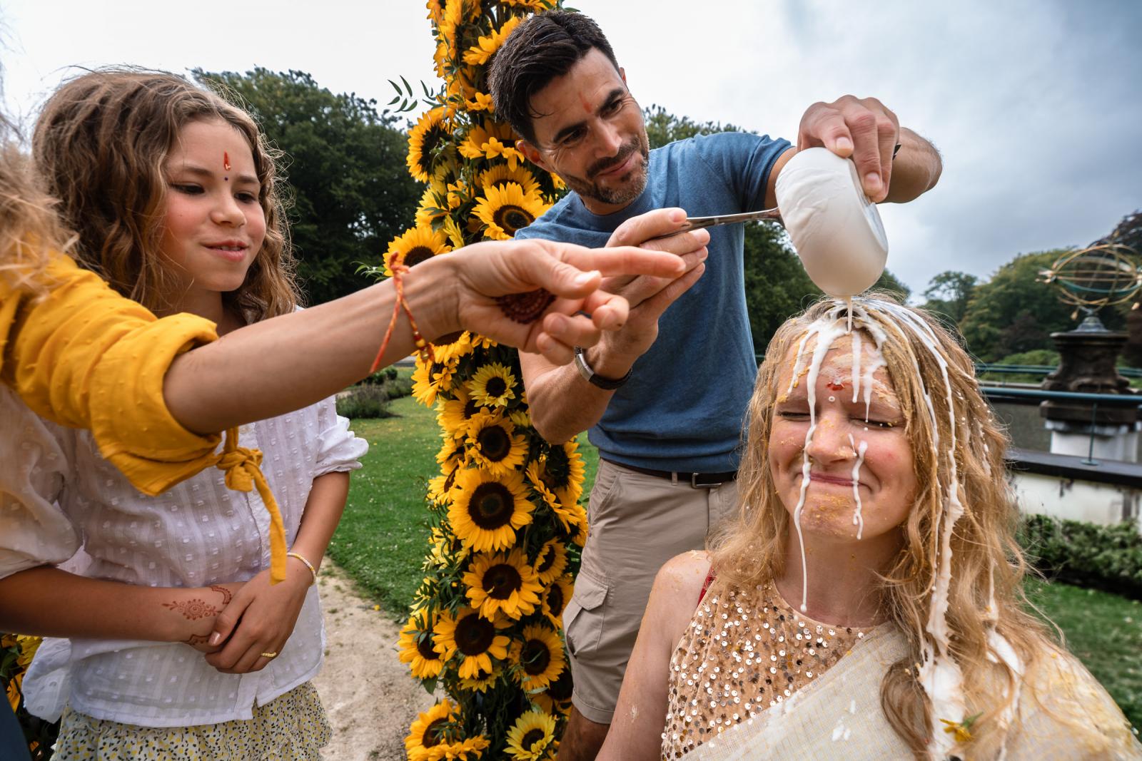 Bruid krijgt yoghurt over haard hoofd tijdens Indiase Haldi ceremonie op terras van Landgoed Duin en Kruidberg