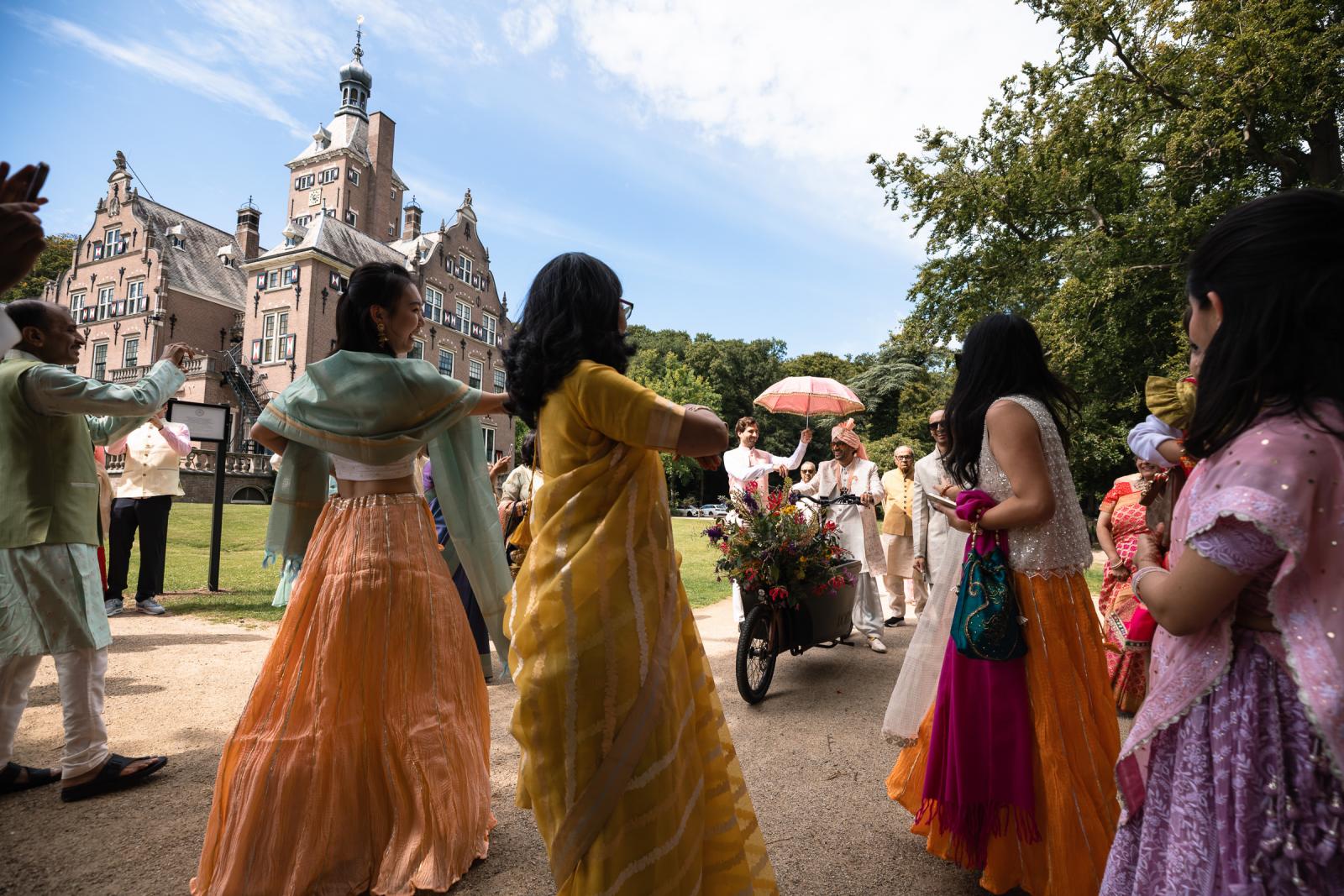 Baraat ceremonie met aankomst bruidegom op bloemenbakfiets bij Landgoed Duin en Kruidberg