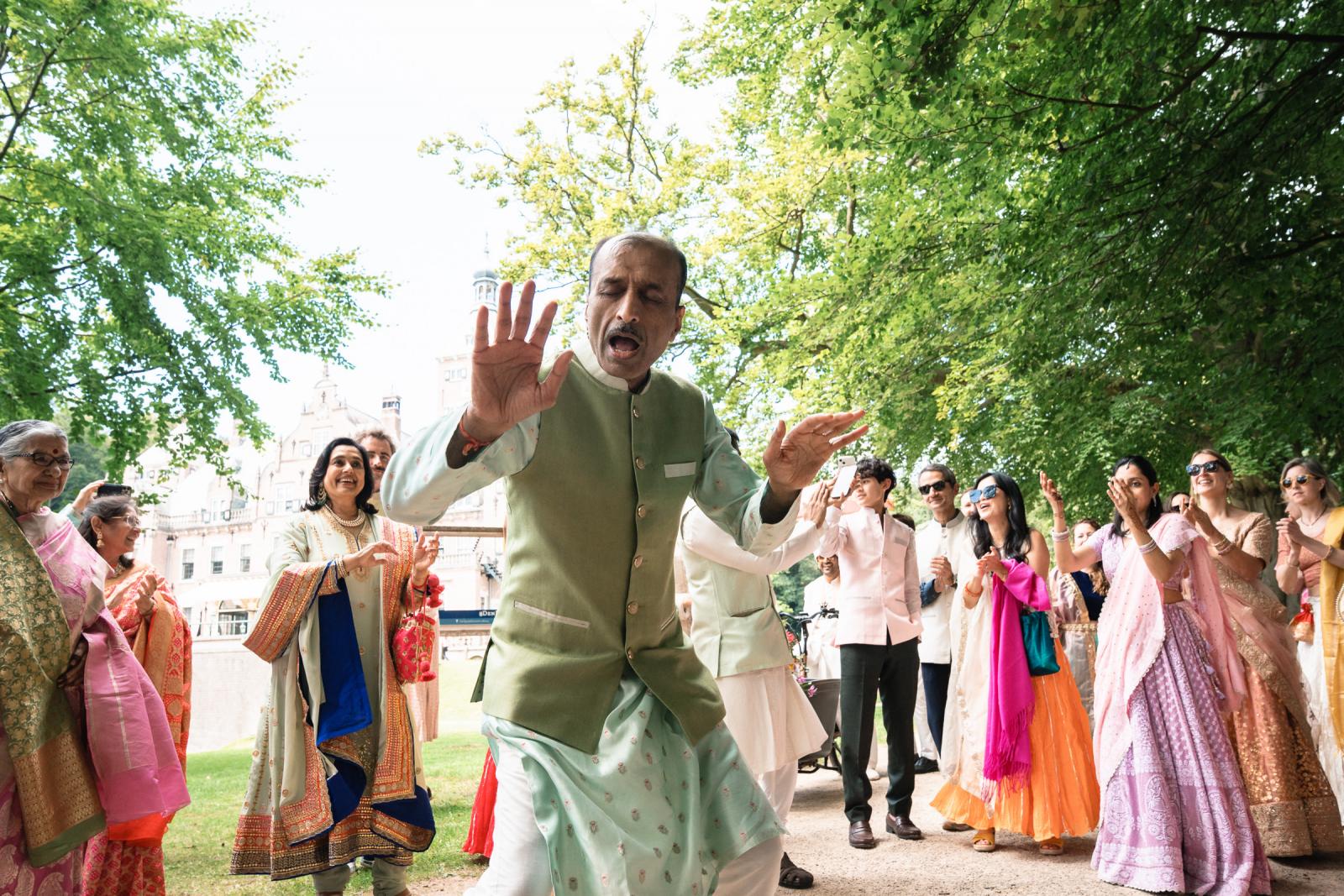 Dansende familie en vrienden tijdens feestelijke Baraat op exclusieve trouwlocatie Nederland