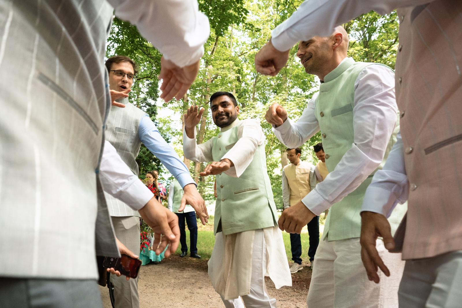 Dansende vrienden en familie tijdens feestelijke Baraat op exclusieve trouwlocatie Nederland