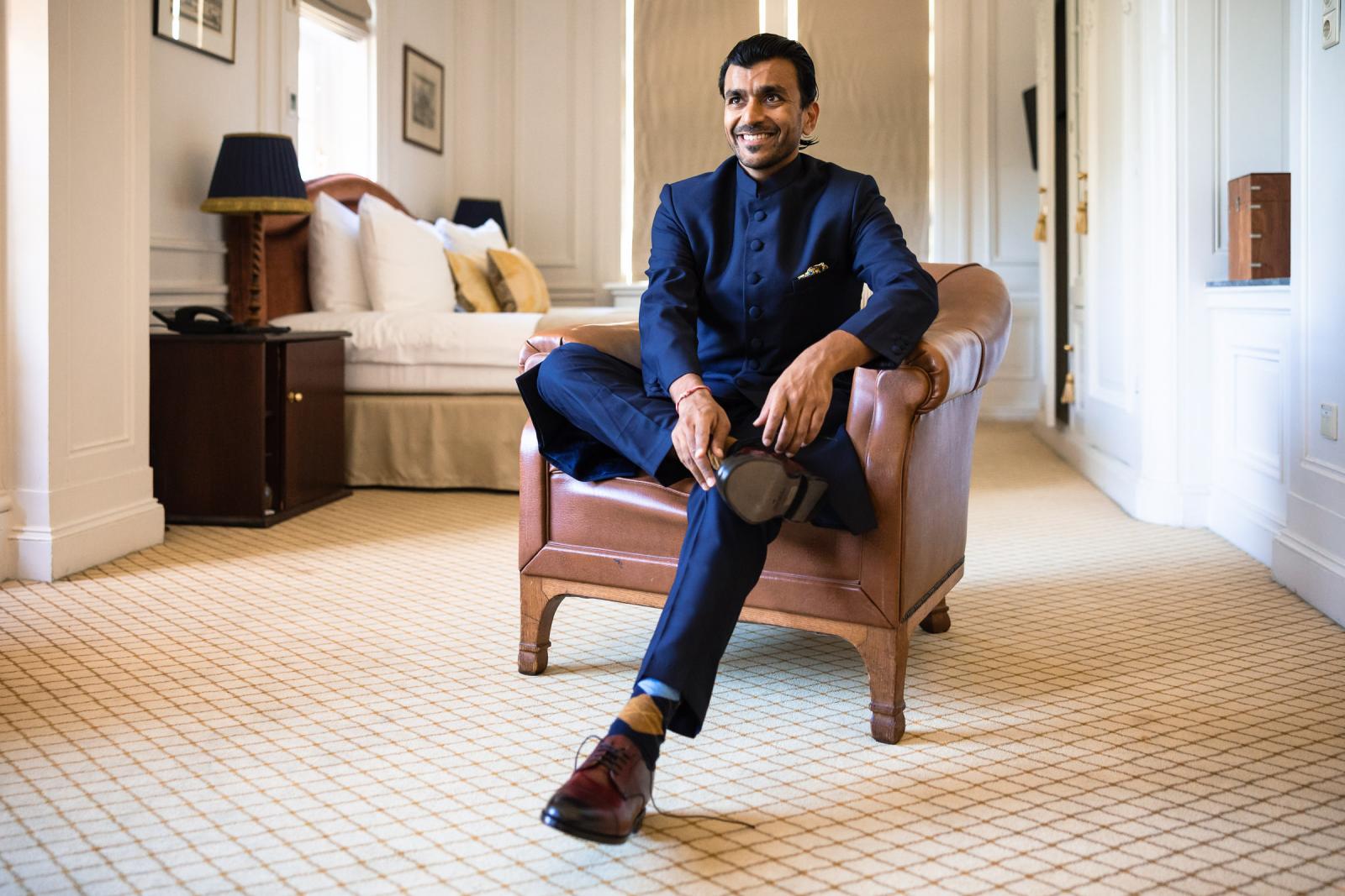 Bruidegom Nilesh maakt trek trouwschoenen aan in luxe kamer van Duin en Kruidberg