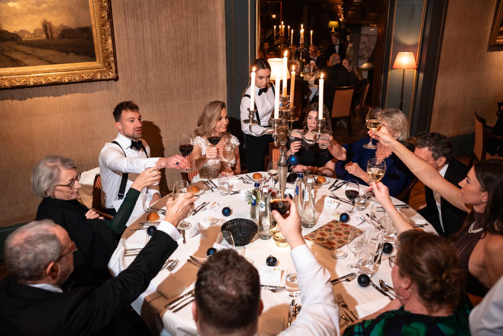 Diner: familie proost samen aan mooi gedekte tafel met kaarsen.