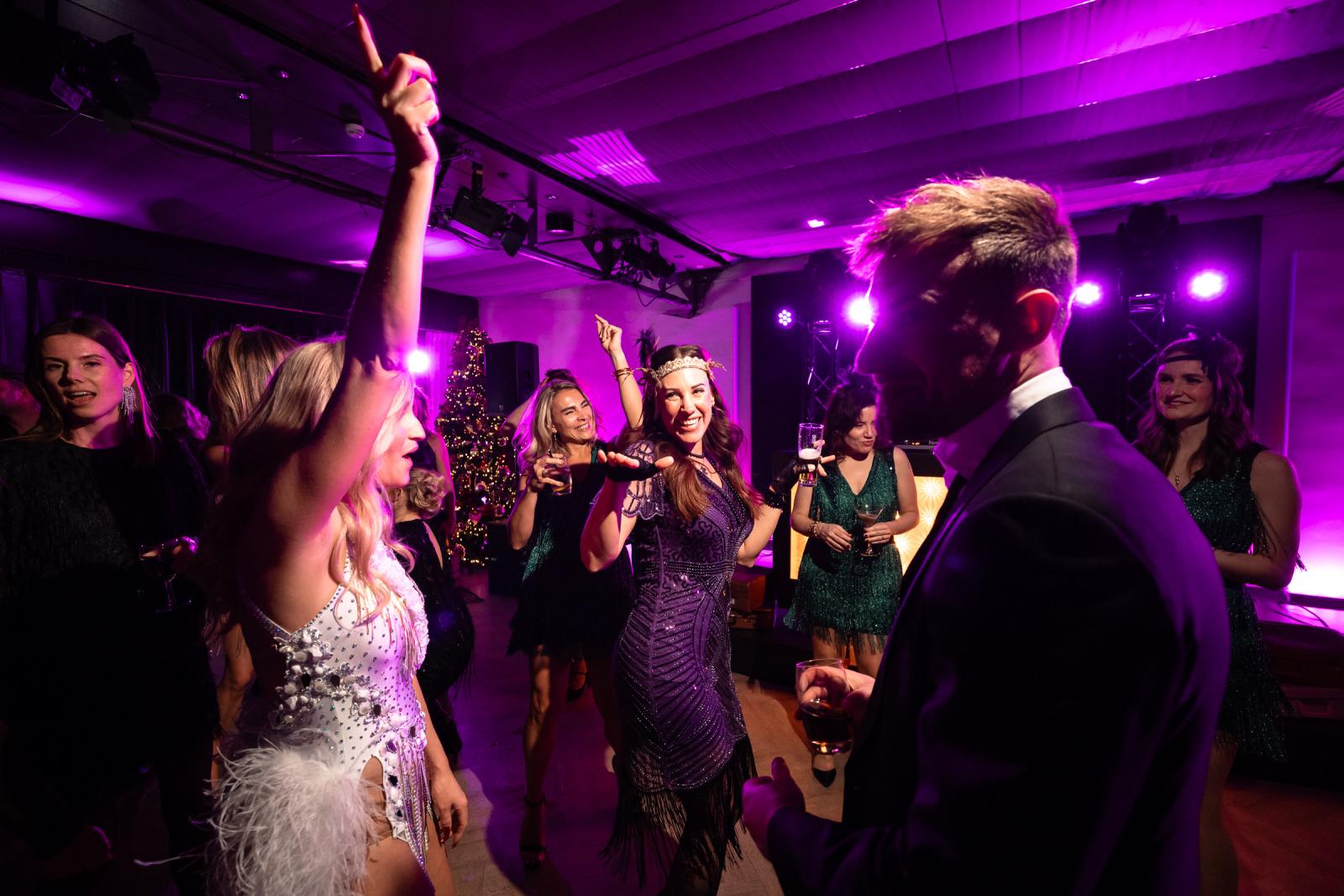 Dansvloer vol gasten in roaring twenties outfits tijdens kerstbruiloft.