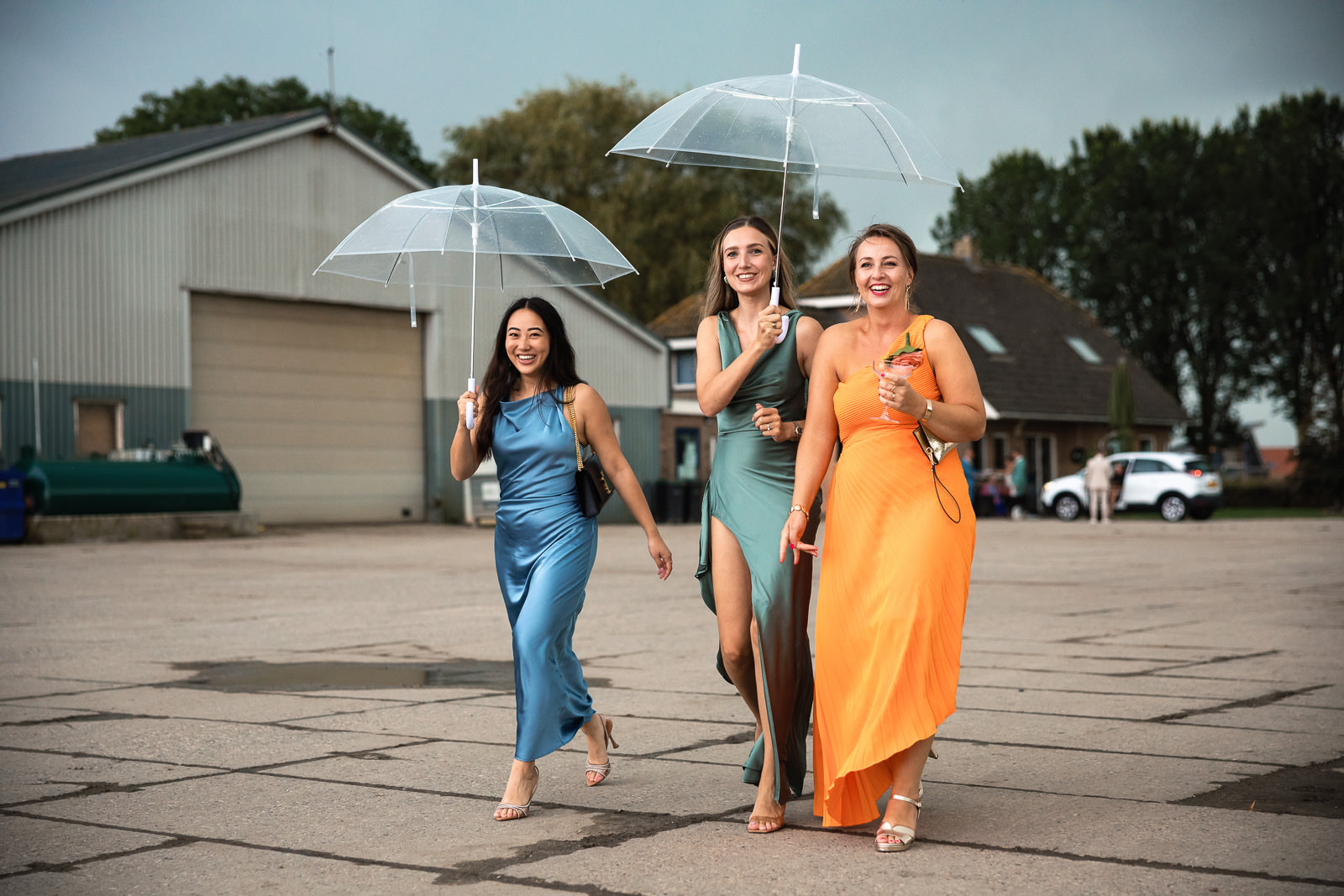 Bruidsgasten lopen door de regen door Trouwfotograaf Almere