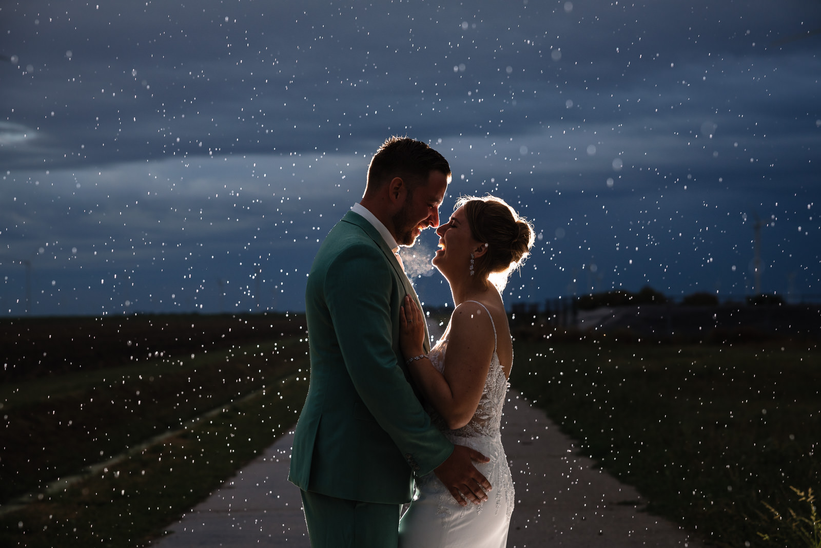 Creatieve foto met bruidspaar in de regen door Trouwfotograaf Almere