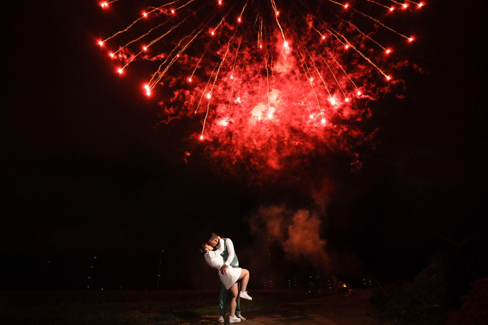 Kussend bruidspaar onder vuurwerk op hun bruiloft door Trouwfotograaf Almere