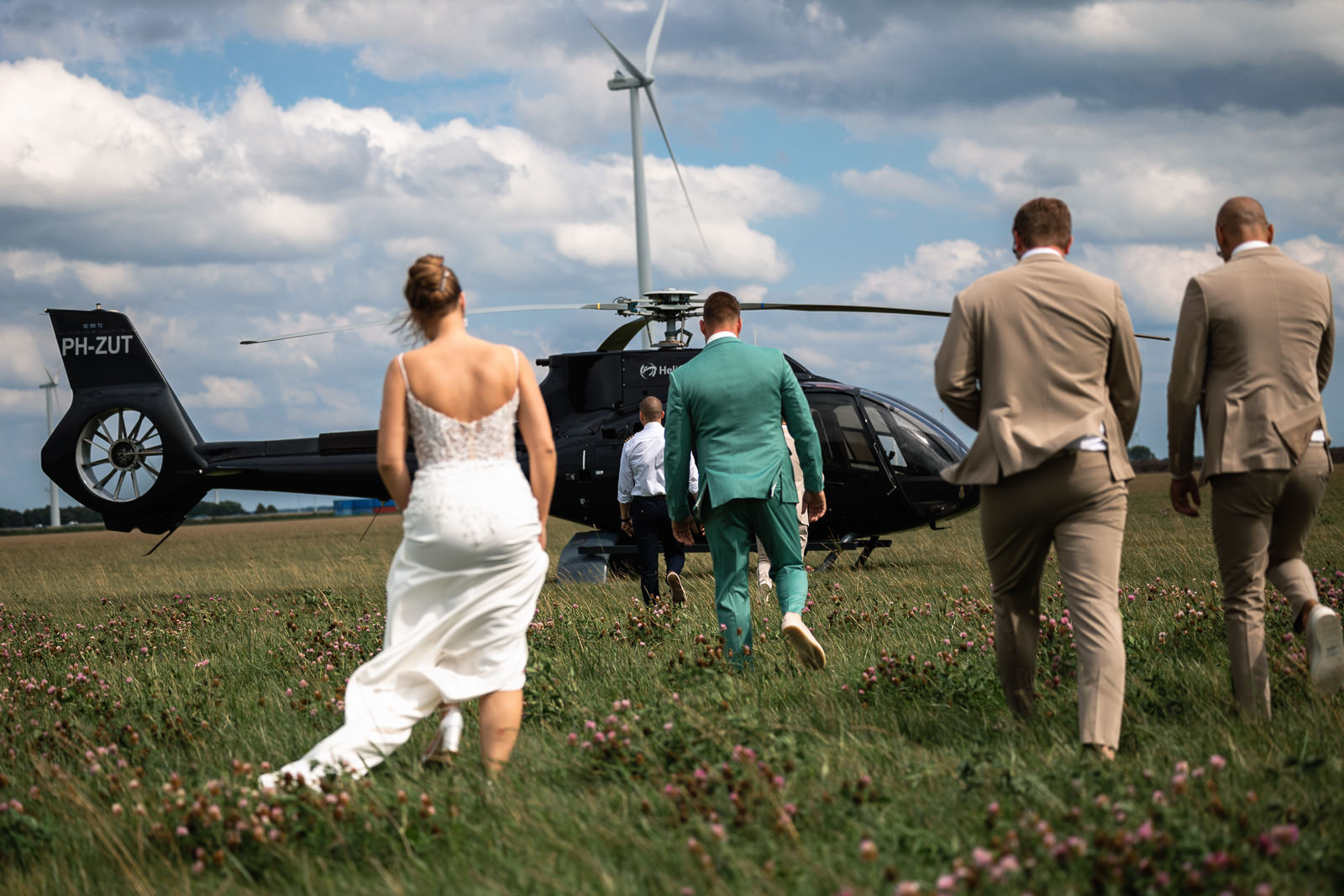 Bruidspaar loopt naar helicopter als trouwvervoer door Trouwfotograaf Almere