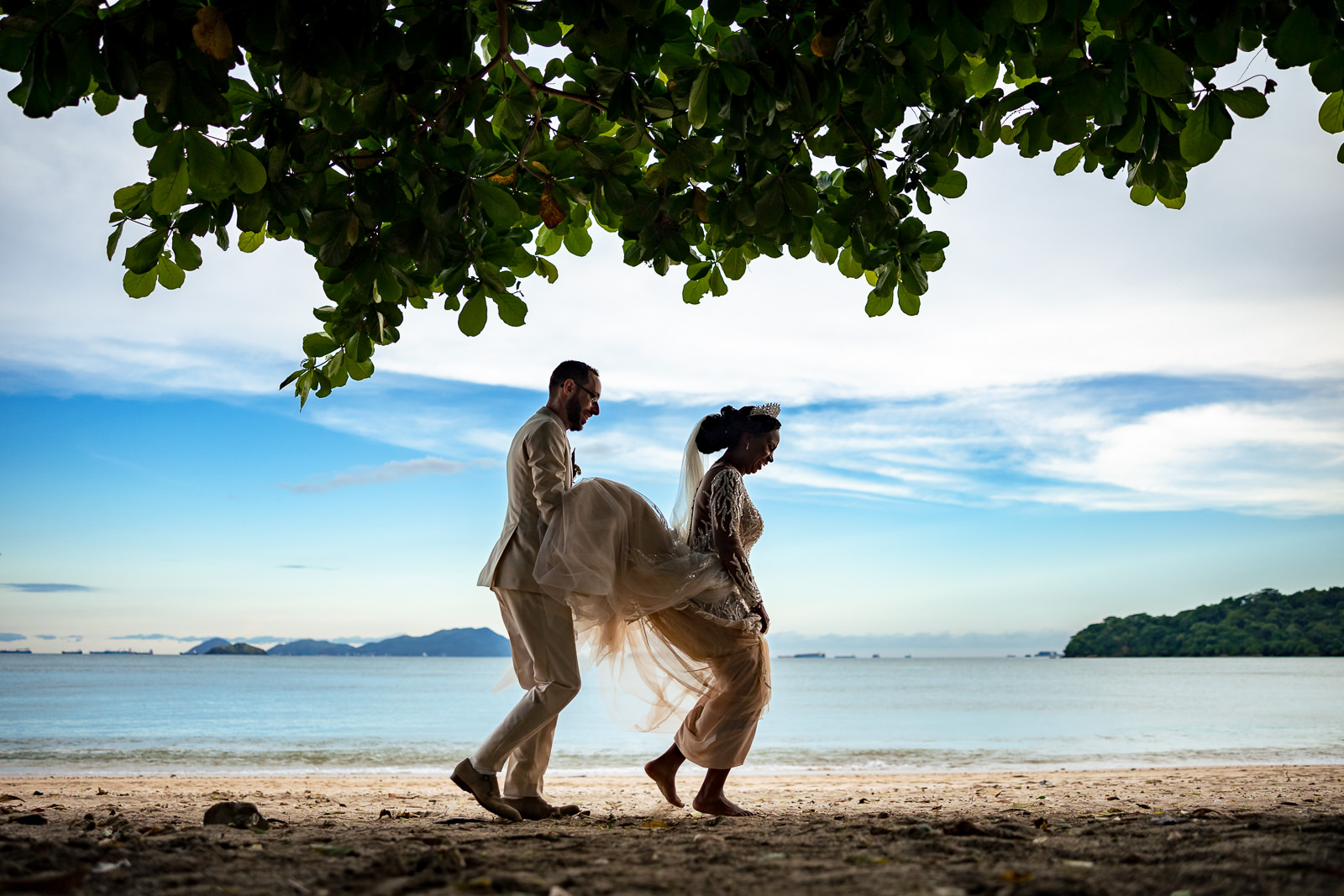 Destination wedding photographer Panama groom helps bride with the dress