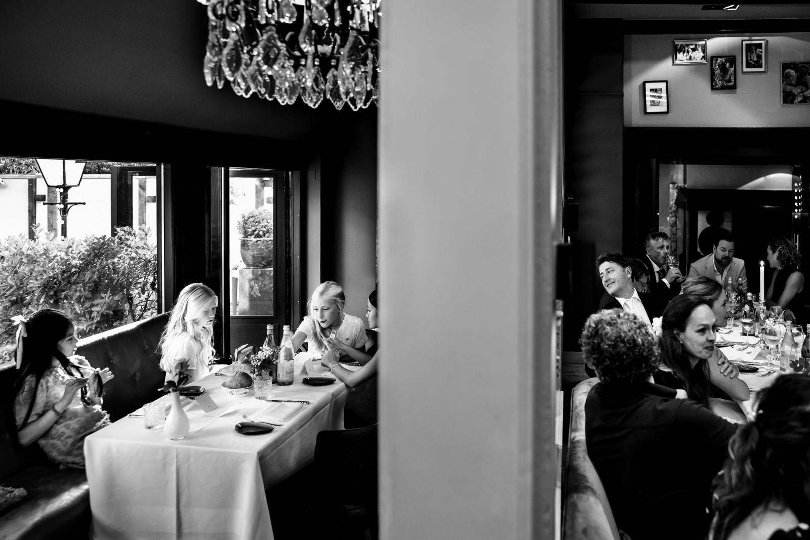 Bruidegom kijkt en geniet van de bruidsmeisjes met hun vriendinnen tijdens het diner