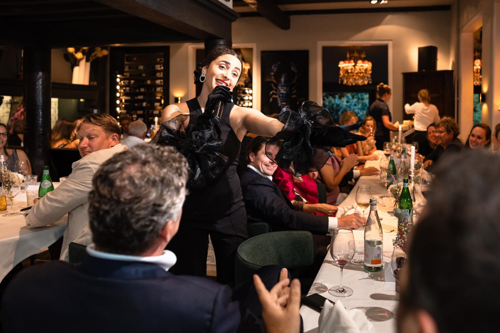 De zangeres treedt op tussen de tafels tijdens het diner.