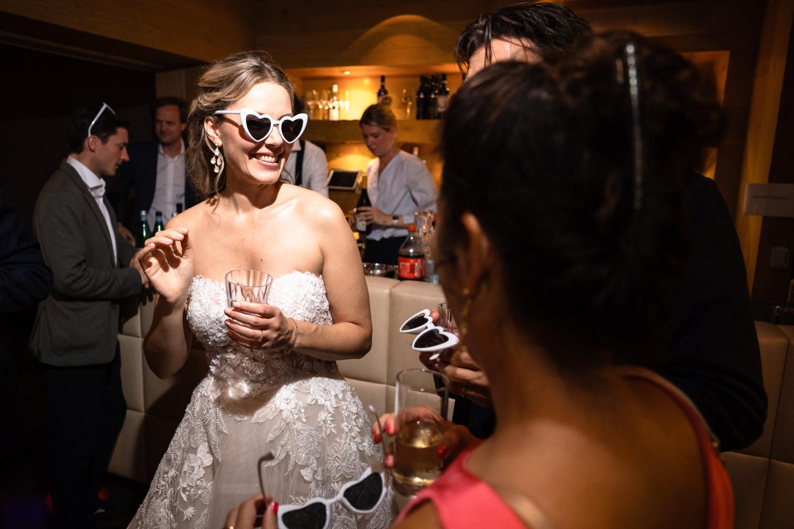 Lachende bruid met hartjes feest bril op