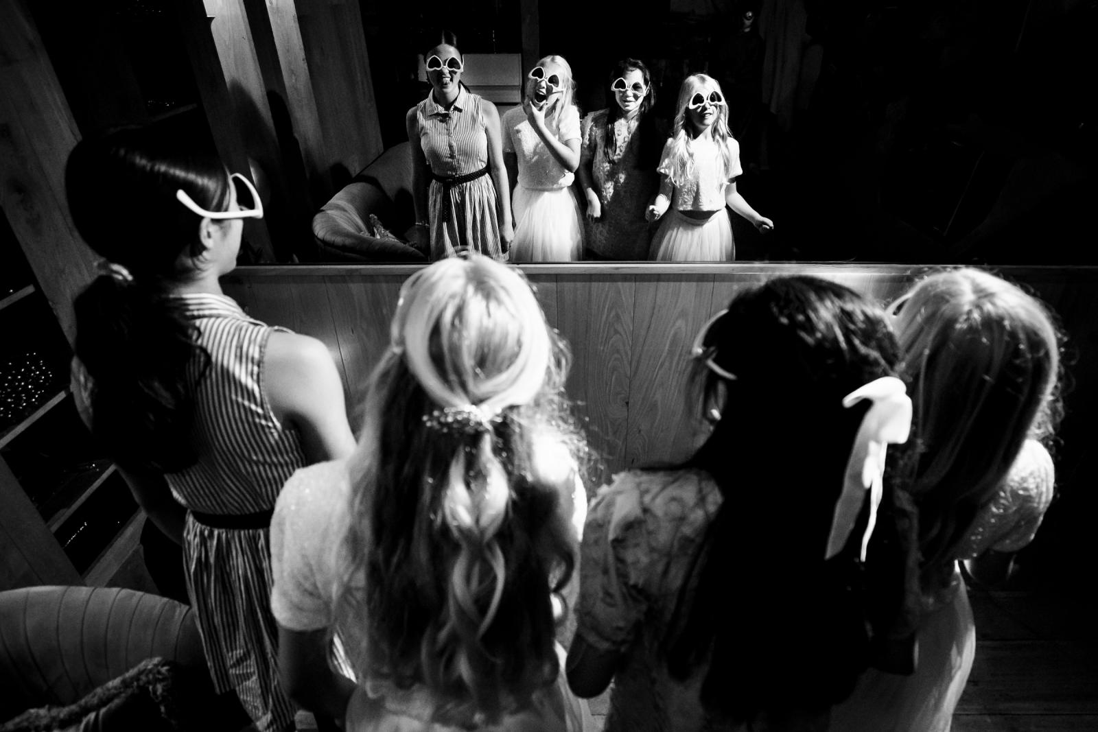 Bruidsmeisjes met vriendinnen spelen met de hartjes feestbrillen en dansen voor de spiegel