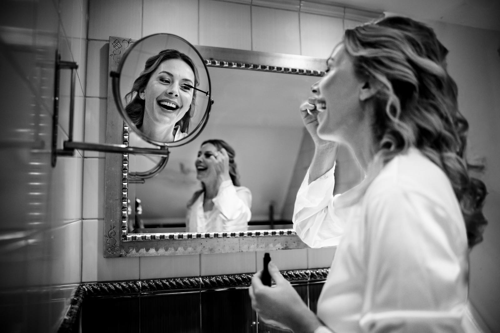 De bruid doet haar makeup op in de badkamer