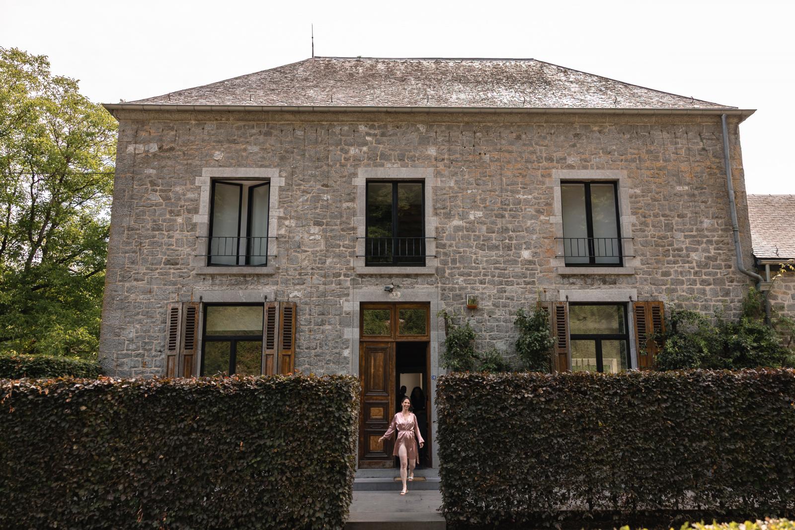 Bruid loopt naar hun kamer om trouwjurk aan te doen Destination Wedding La Carriere Ardennen Belgie 