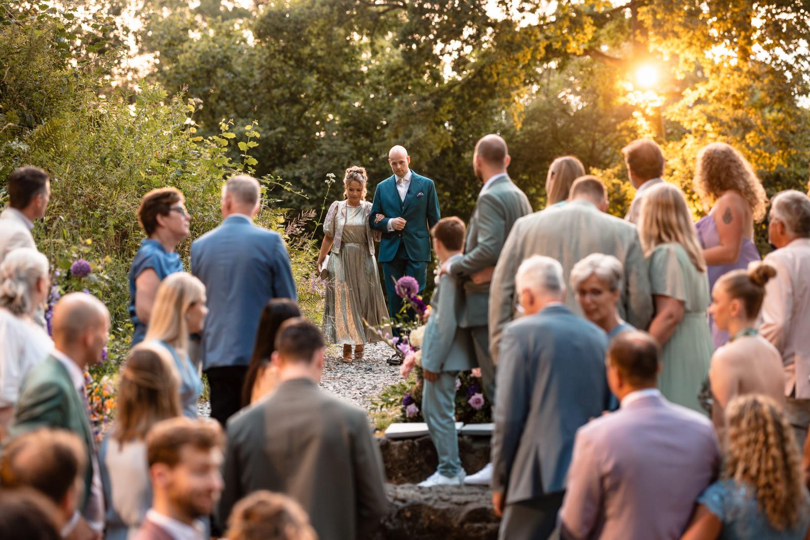 Opkomst bruidegom met moeder bij Ceremonie Destination Wedding La Carriere Ardennen Belgie 