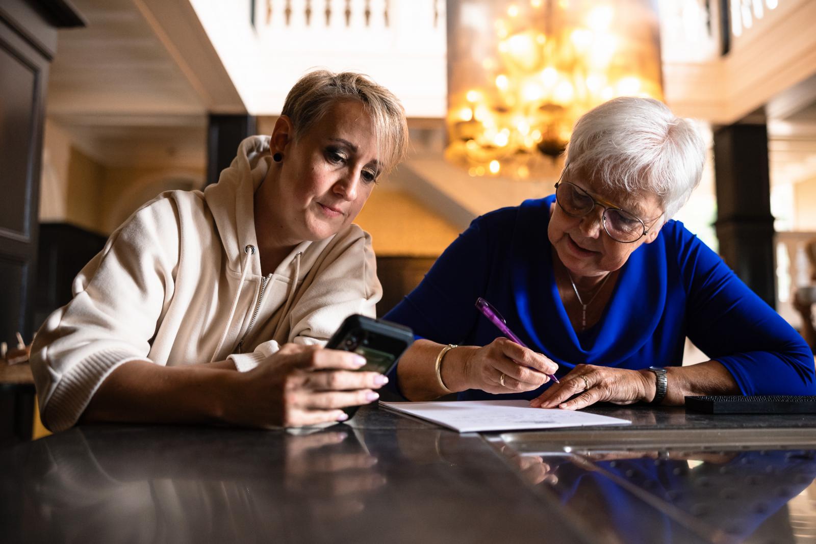 De bruid schrijft de geloftes met haar moeder aan tafel tijdens de voorbereidingen in het kasteel.