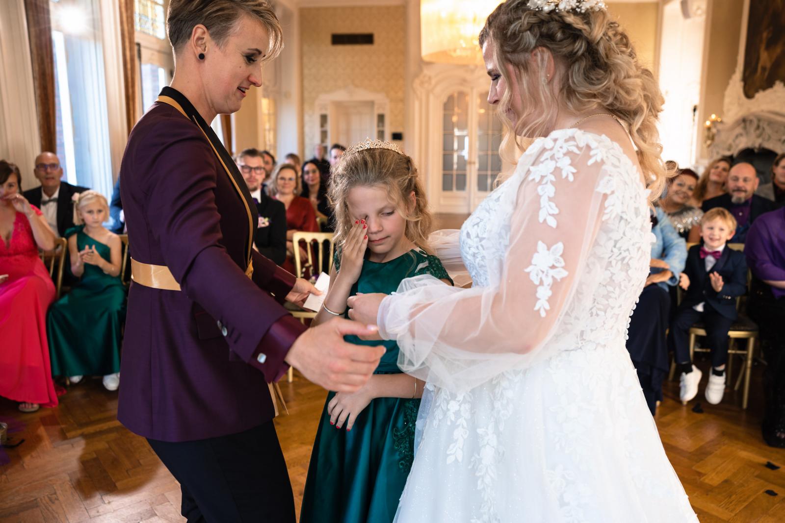 Ontroerend moment tijdens de ceremonie waarin de bruiden hun dochter betrekken bij het geven van de ring.
