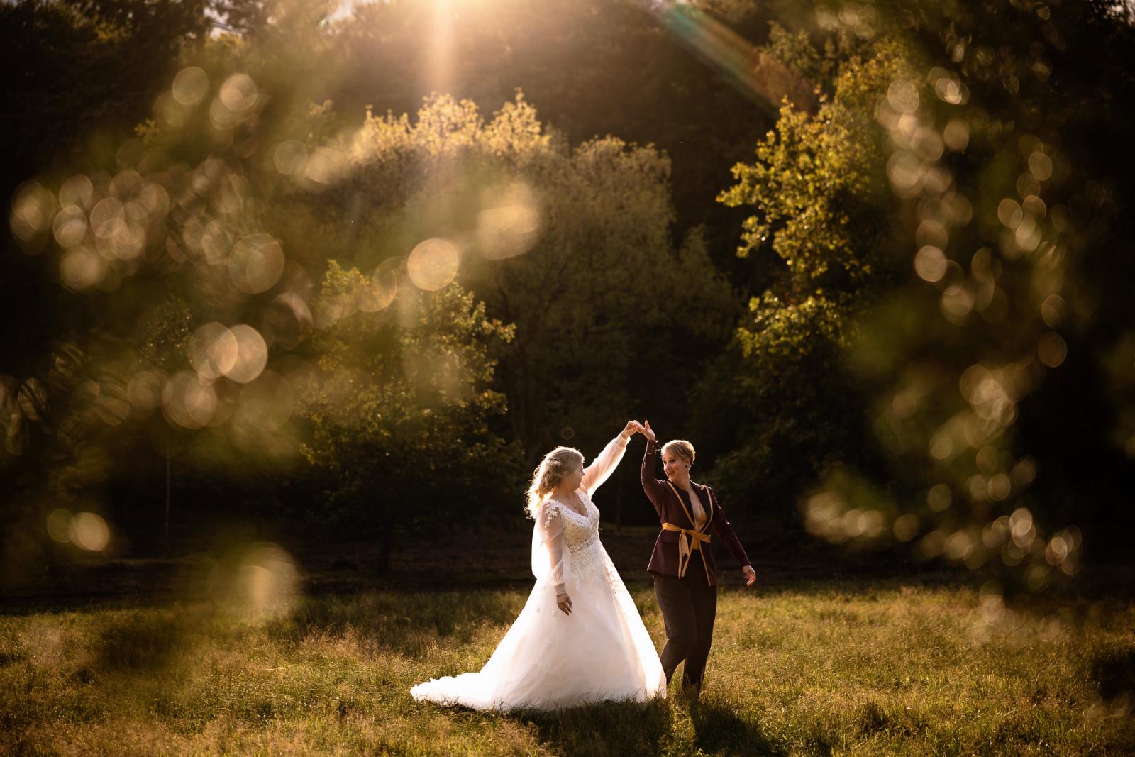 De bruiden dansen samen in het avondlicht tijdens de golden hour shoot buiten het kasteel.