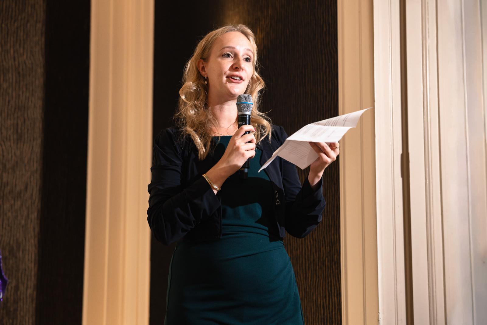 Close-up van een vrouw die een emotionele speech geeft tijdens het trouwdiner.