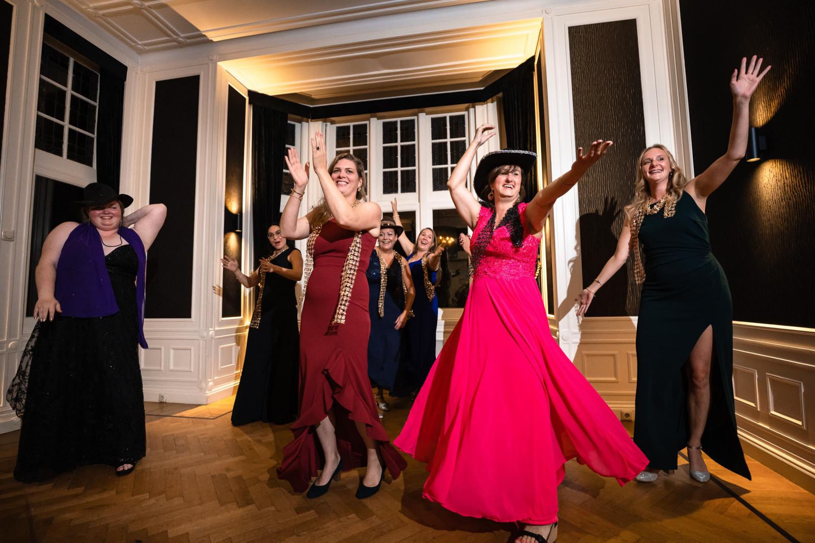 Vriendinnen voeren een dansoptreden op voor het bruidspaar tijdens het avondfeest.