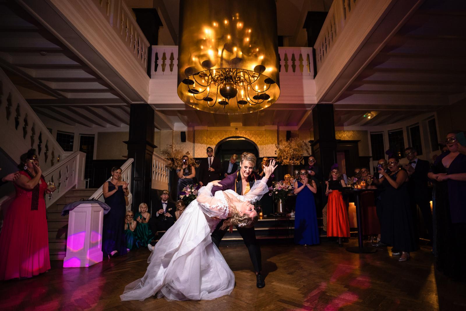 De twee bruiden voeren hun openingsdans uit onder de grote kroonluchter in de feestzaal van Kasteel De Hooge Vuursche.