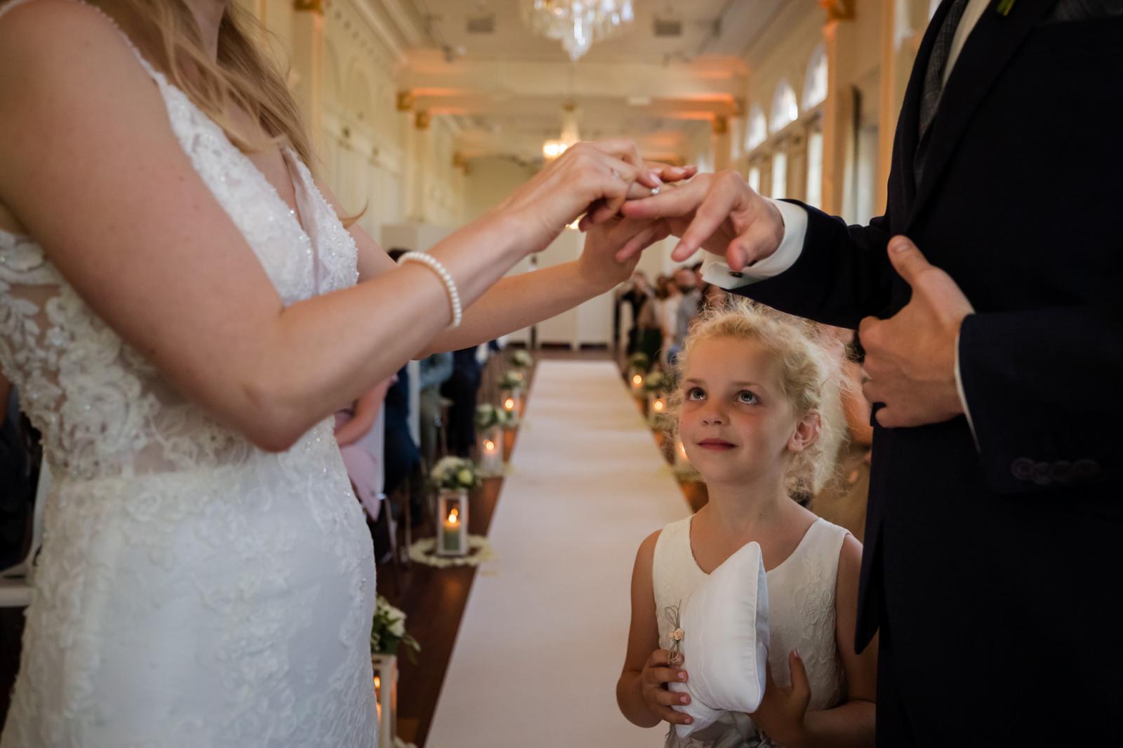dochter kijkt hoe de ringen omgedaan worden tijdens trouwceremonie Wereld Museum Rotterdam