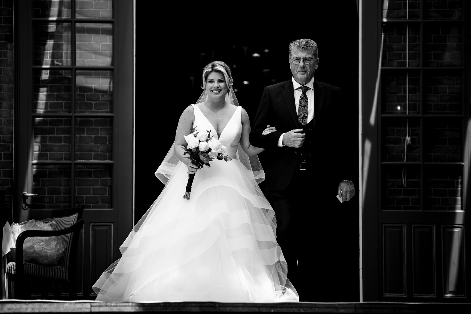 Bruid komt met vader de kasteel trap aflopen voor de ceremonie Trouwfotograaf Den Haag