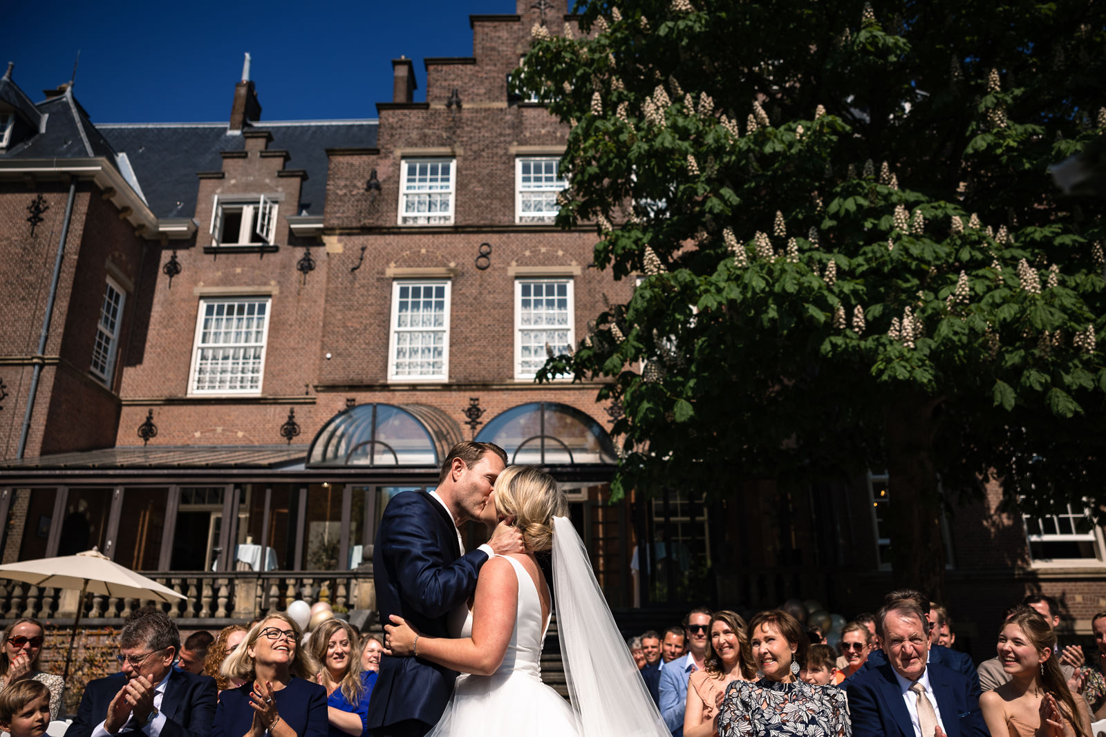 Eerste kus bruidspaar tijdens kasteel huwelijks ceremonie Trouwfotograaf Den Haag