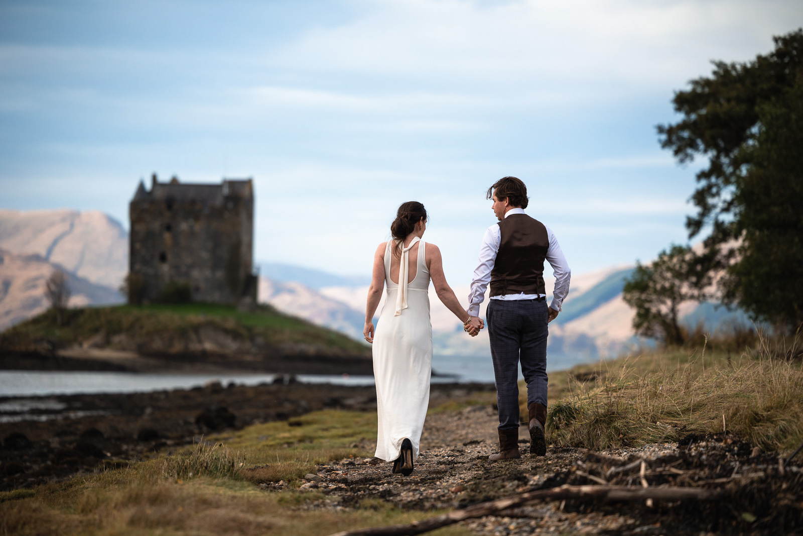 Couple walking to Castle Eloping in Highlands Scotland with Wedding Photographer
