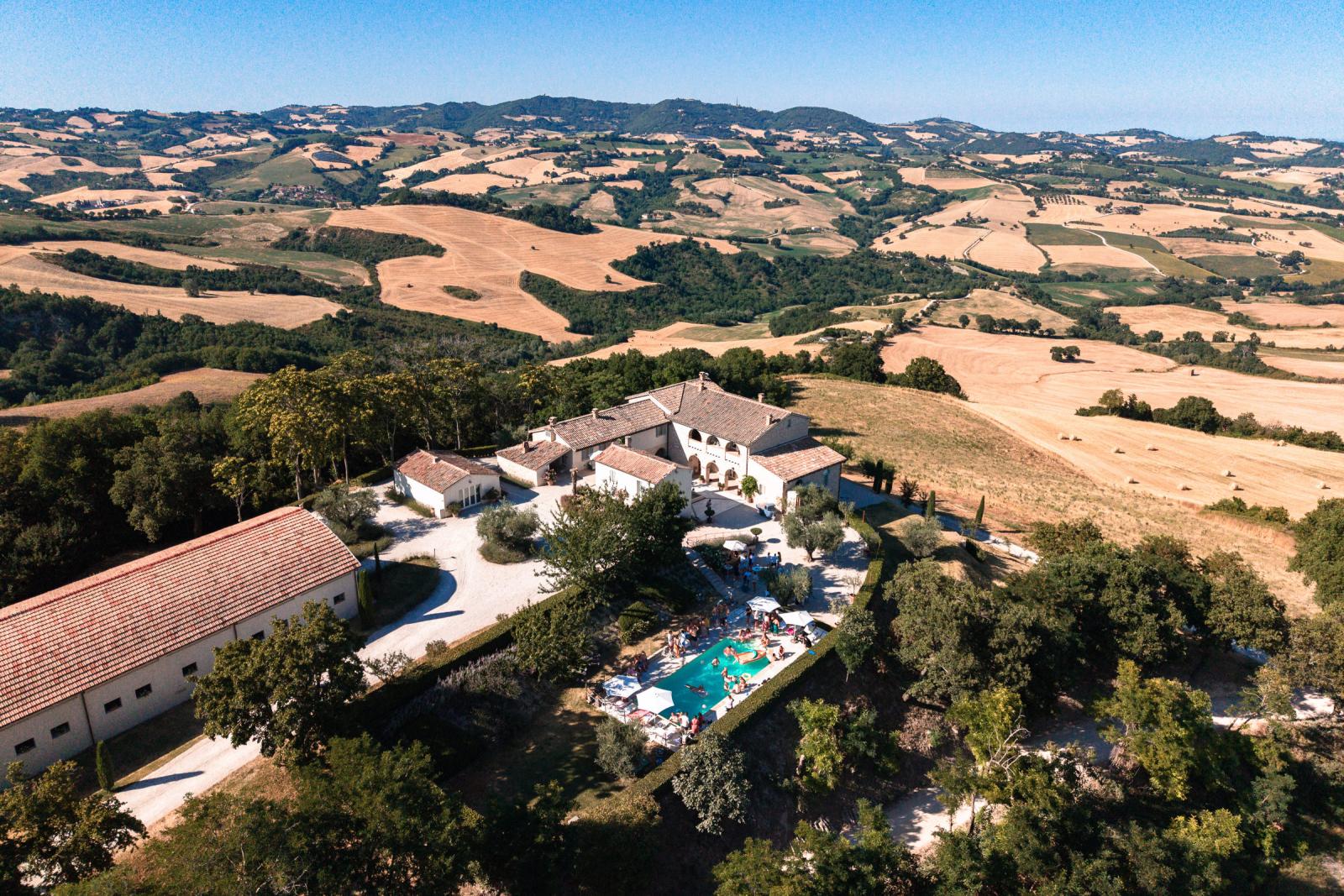 Aerial drone photo of Le Stonghe wedding venue surrounded by rolling hills in Le Marche Italy
