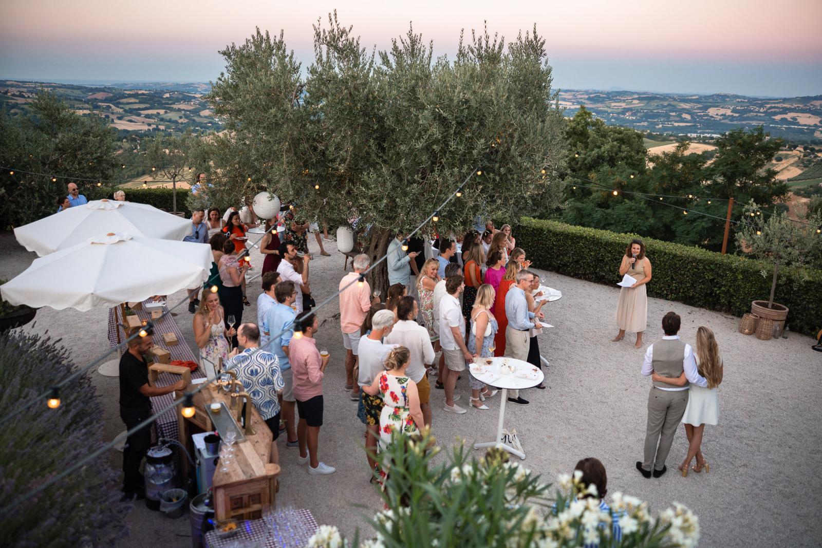 Elevated view of outdoor Italian pizza night reception under string lights at Le Stonghe
