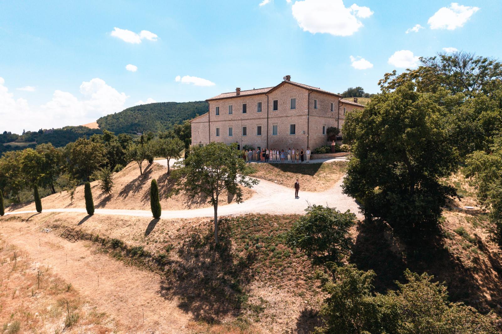 Wide drone shot of Le Stonghe estate in Le Marche as groom waits for the first look