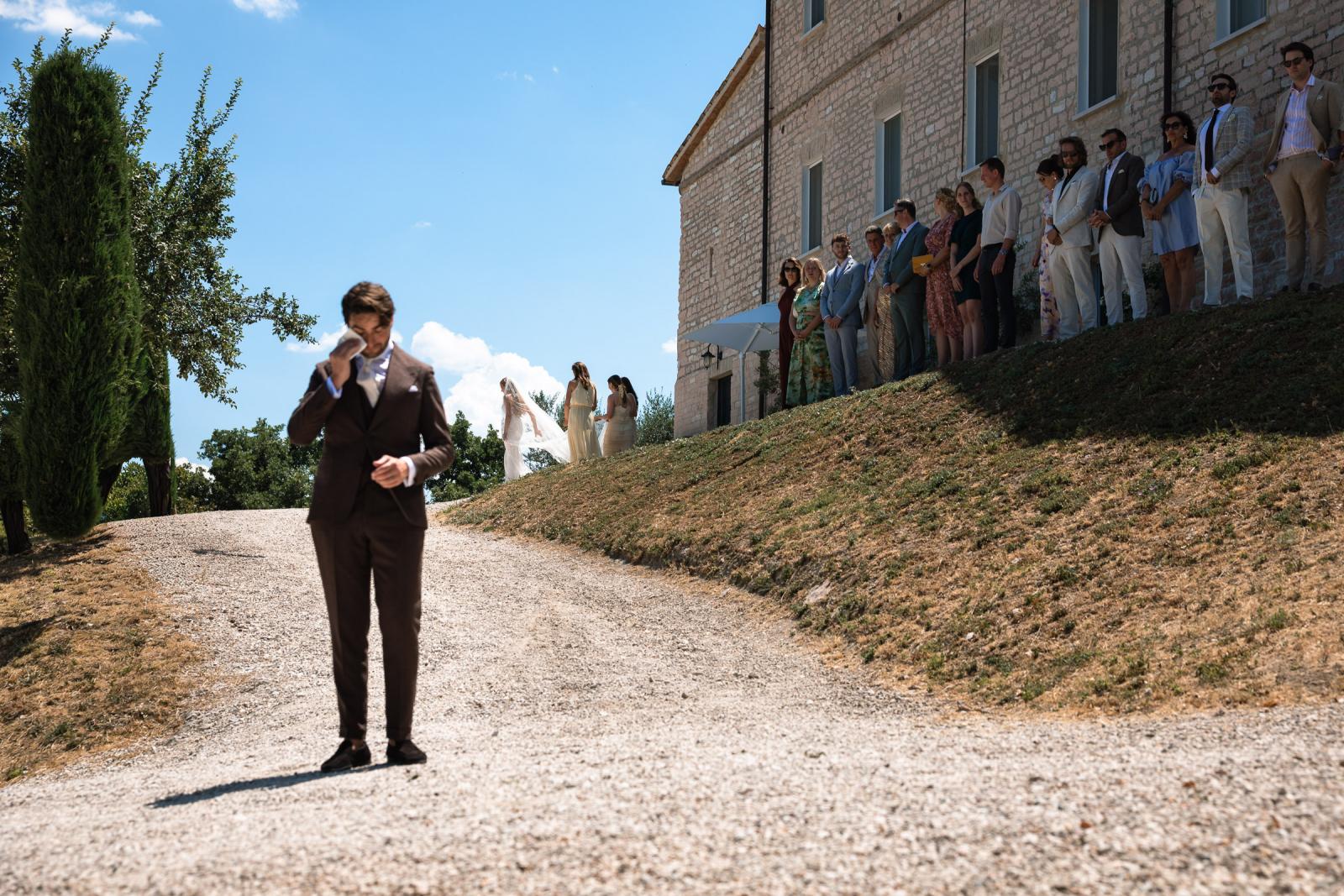 Groom wiping away a tear as he awaits bride Gemmy during first look at Le Stonghe
