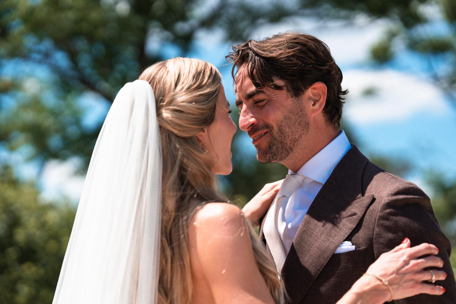 Intimate close-up of bride Gemmy and groom Niels smiling at each other during first look