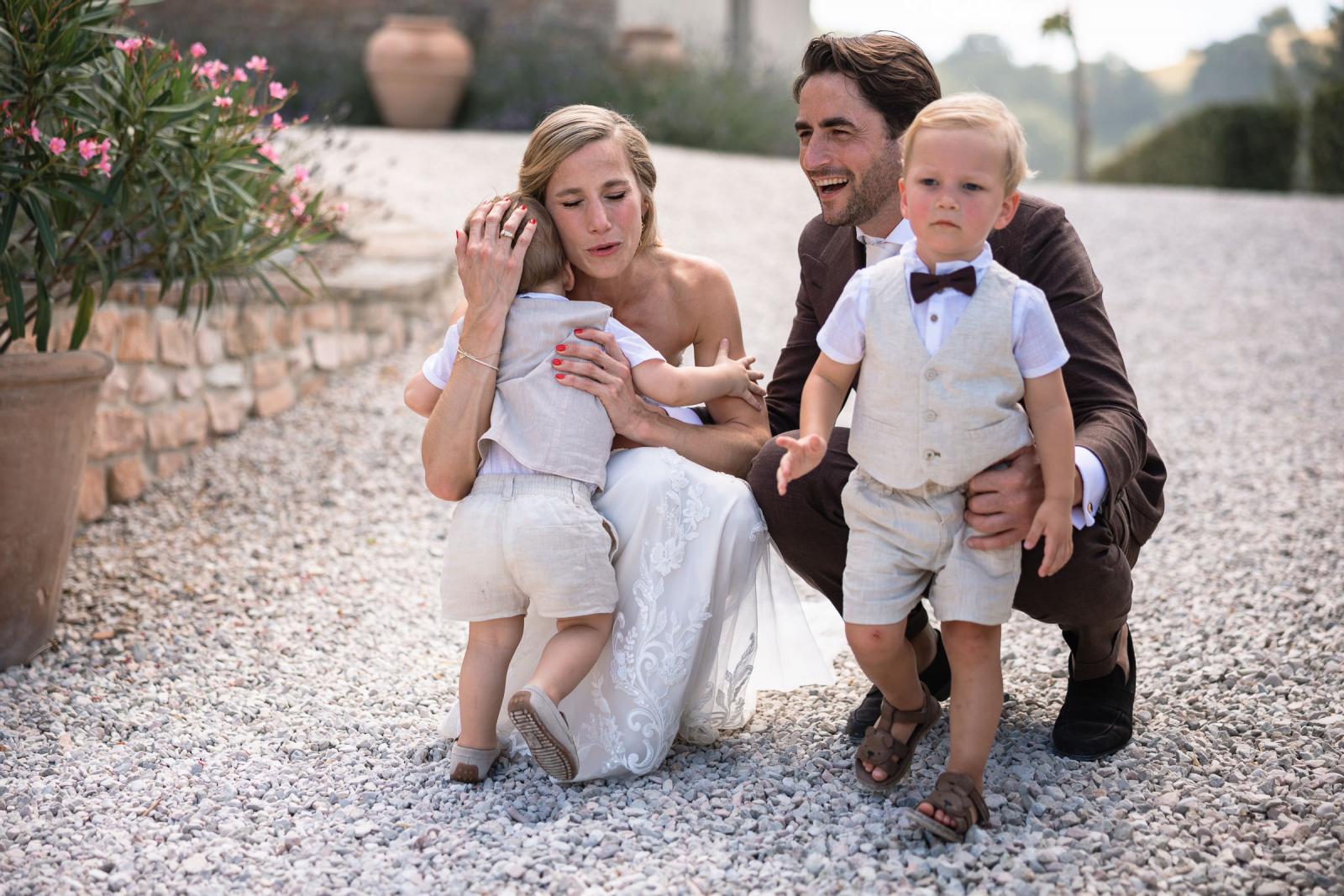 Emotional moment as bride Gemmy hugs young page boy while groom Niels laughs beside them