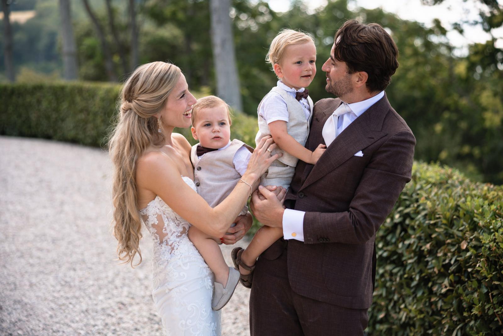 Bride Gemmy and groom Niels holding their two young page boys outdoor at Le Stonghe