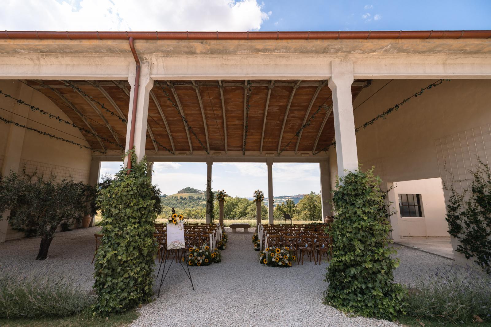 Covered outdoor wedding ceremony setup at Le Stonghe with sunflower floral arrangements and rolling hill views
