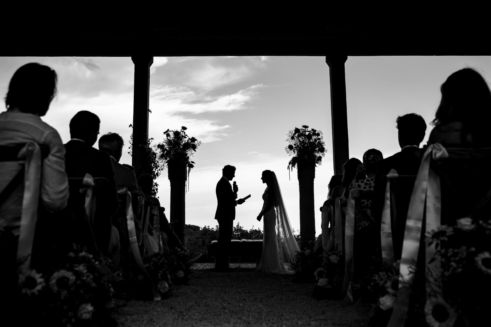 Black and white silhouette of bride and groom during wedding vows at Le Stonghe