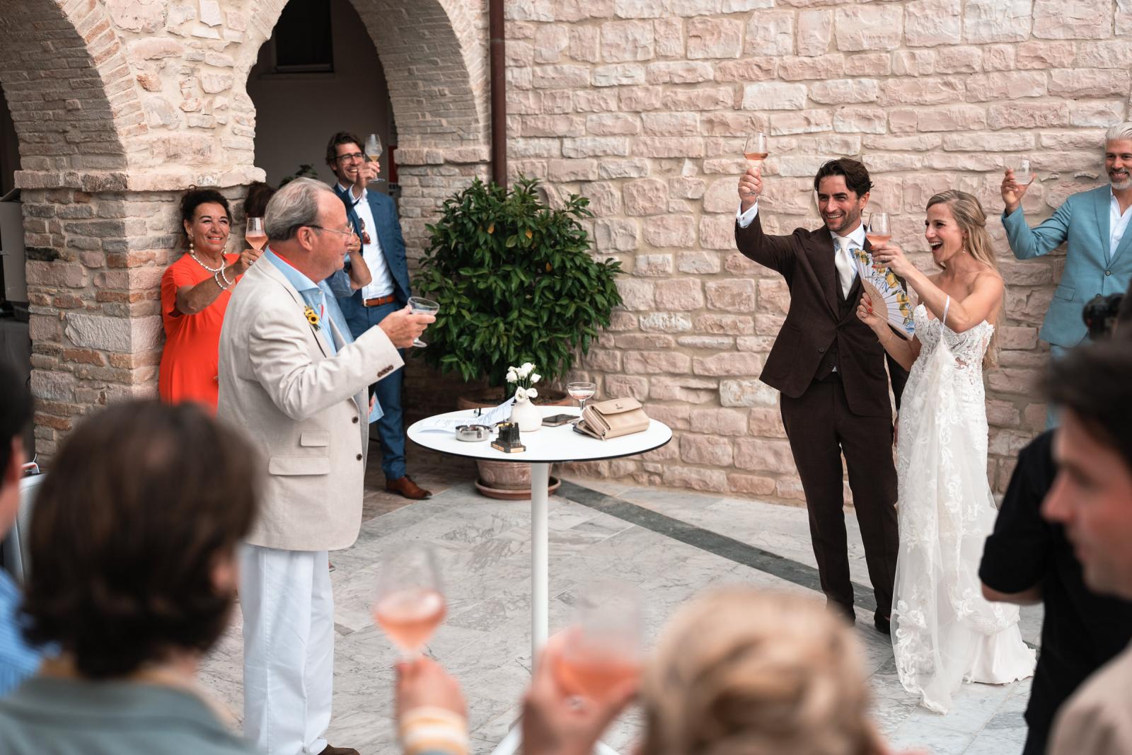 Bride Gemmy and groom Niels raising wine glasses in toast during wedding speeches