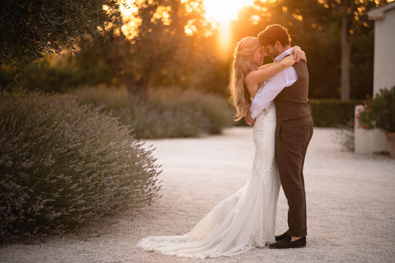 Bride Gemmy and groom Niels embracing outdoors in warm golden hour sunlight at Le Stonghe