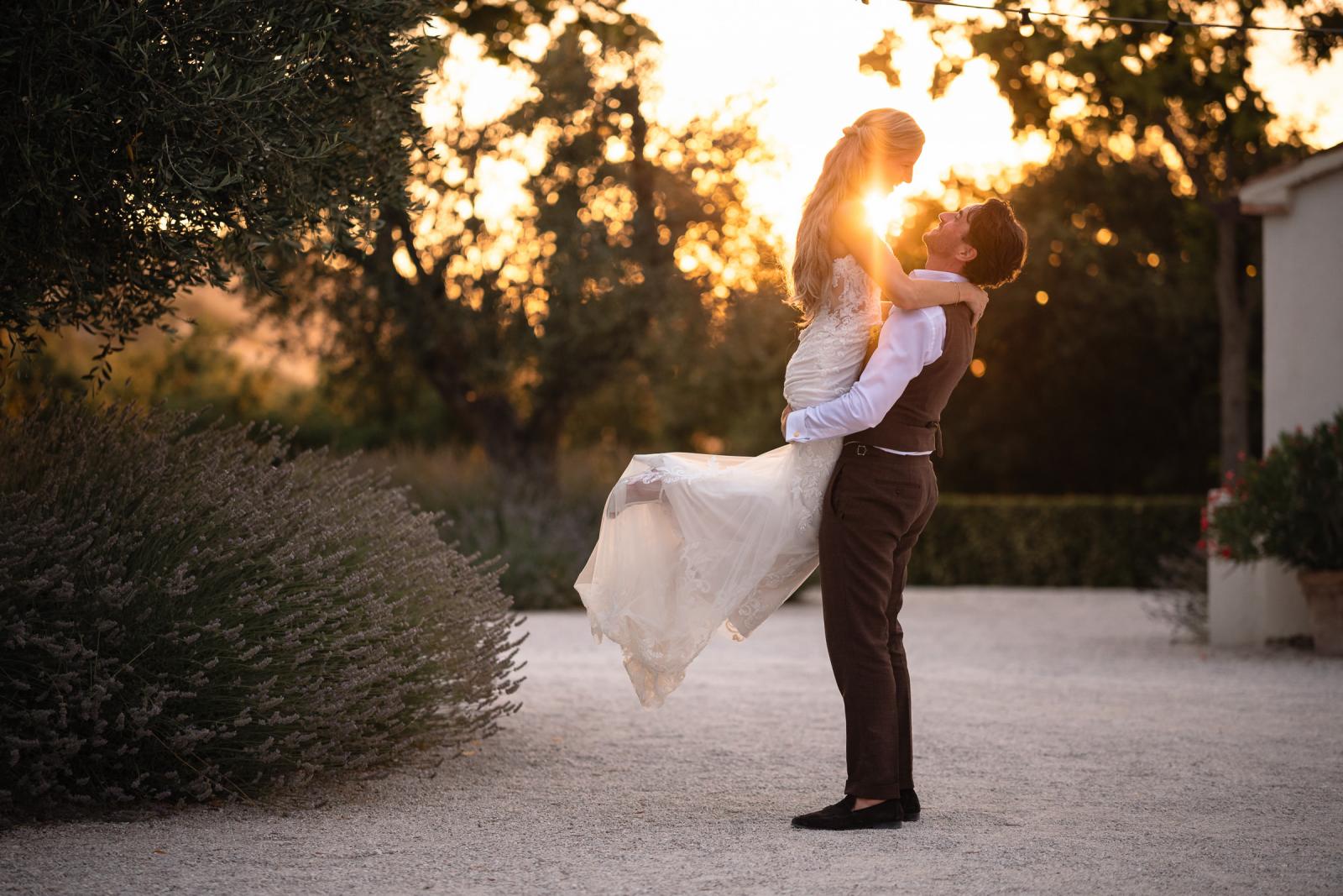 Groom Niels lifting bride Gemmy in his arms during golden hour wedding portraits