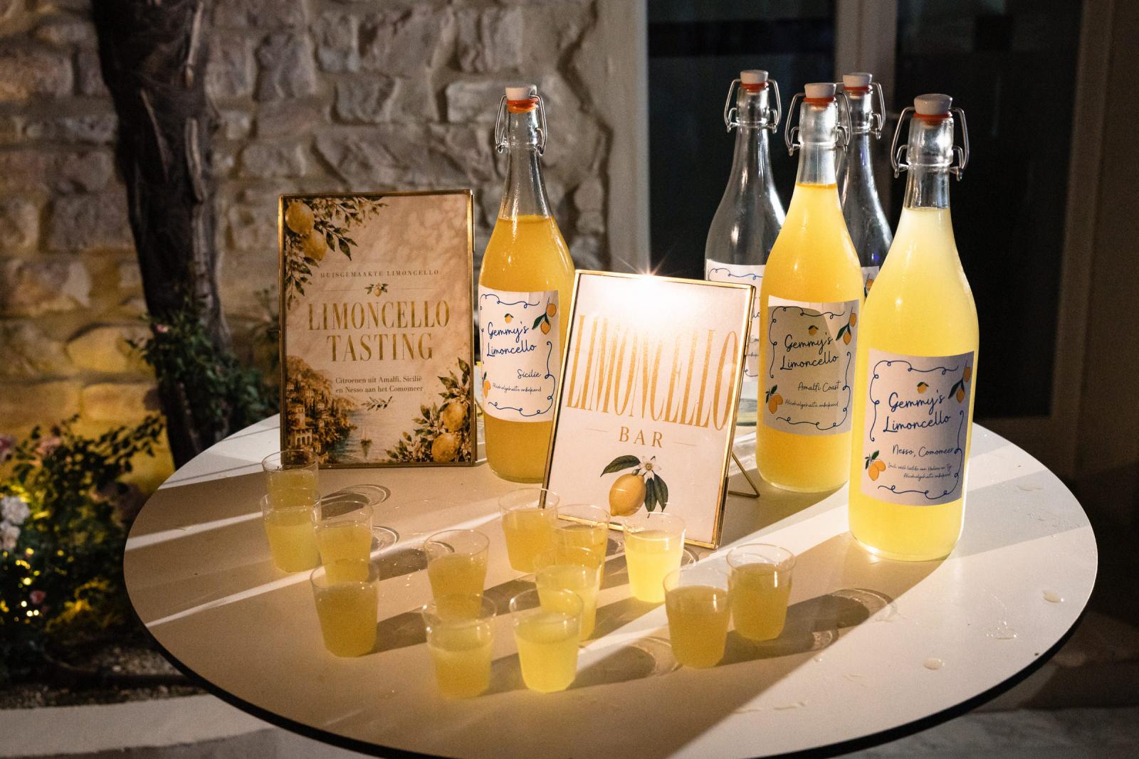 Limoncello tasting bar setup with labeled bottles and shot glasses on round table