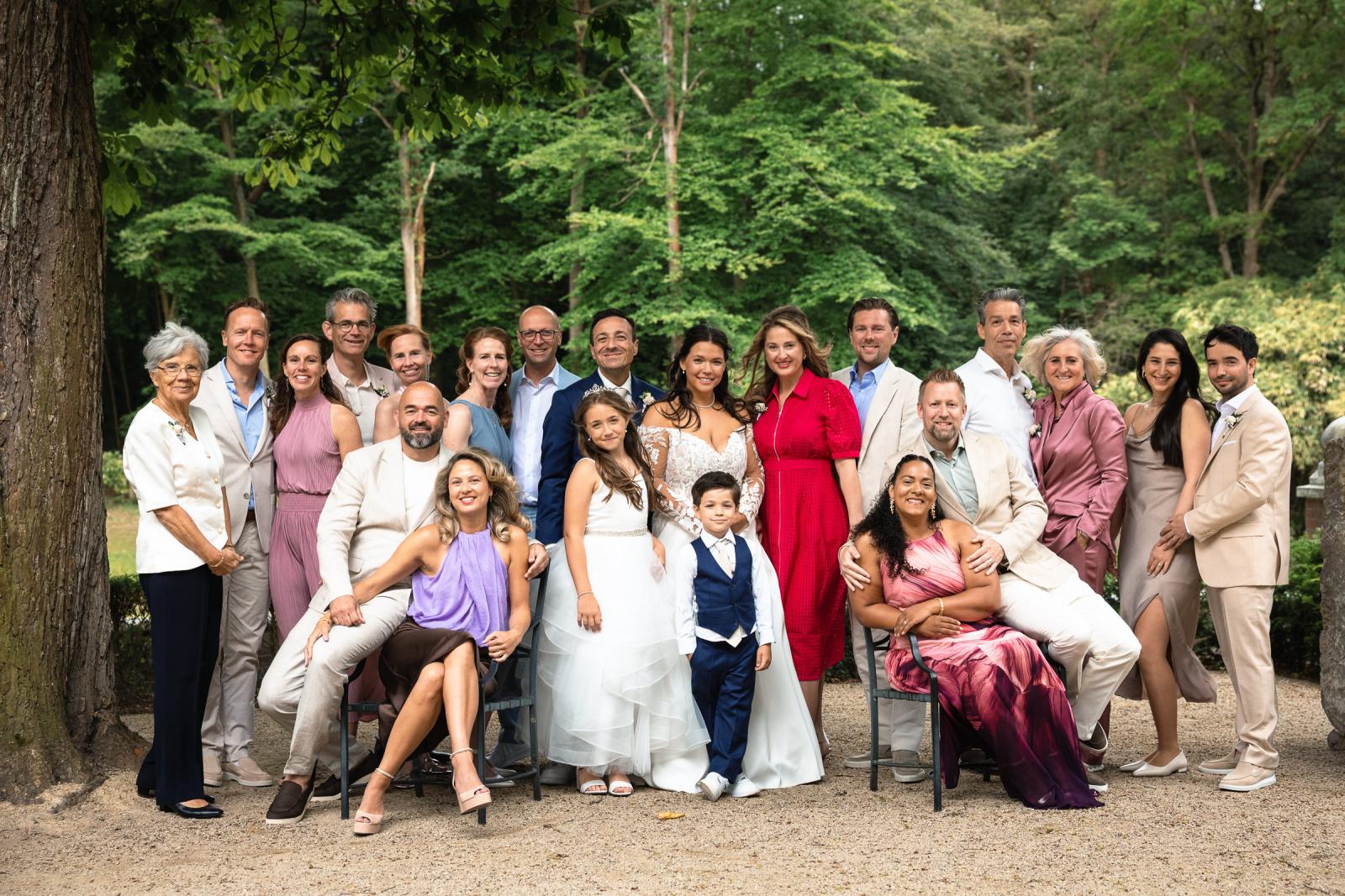 Groepsfoto van bruidpaar George en Iris met hun naaste familie en kinderen op het kasteelterrein.