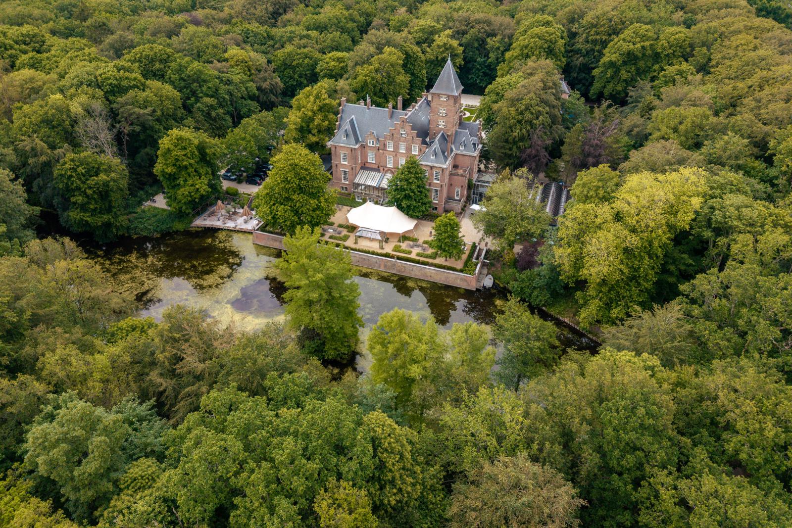 Dronefoto van Kasteel de Wittenburg met de grote stretchtent in de tuin opgebouwd voor de buitenceremonie.